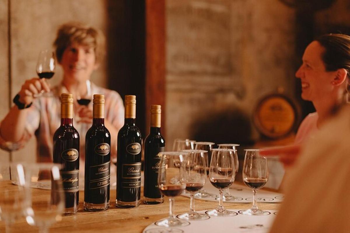um grupo de garrafas de vinho sobre uma mesa com taças de vinho