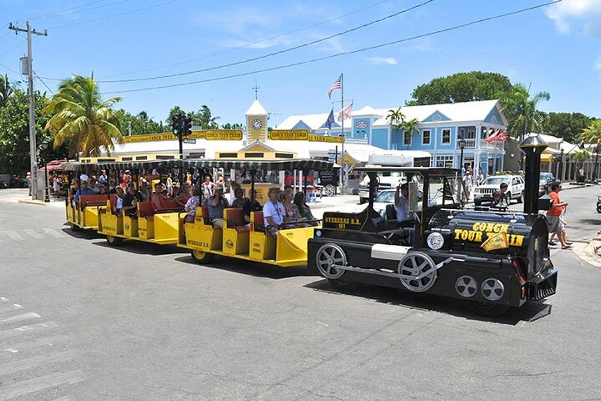 a yellow and black train with people riding on it