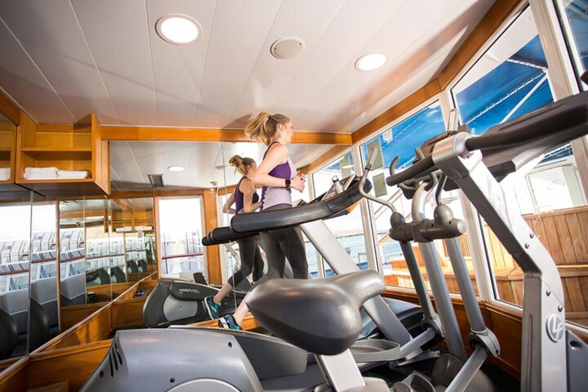 a woman running on a treadmill in a gym