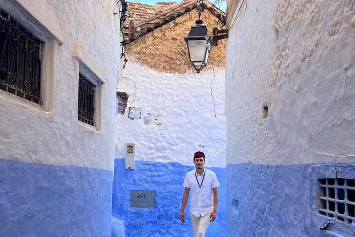 um homem caminhando por um beco azul e branco