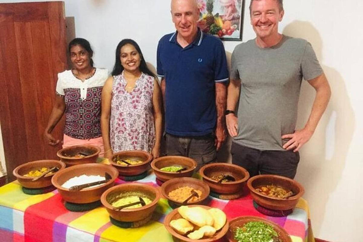 a group of people standing next to a table with bowls of food