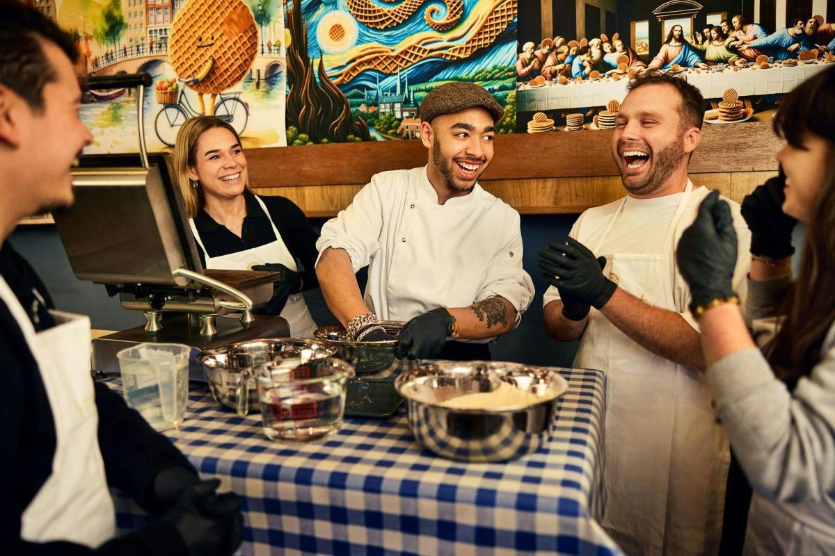 skupina lidí stojících kolem stolu v restauraci