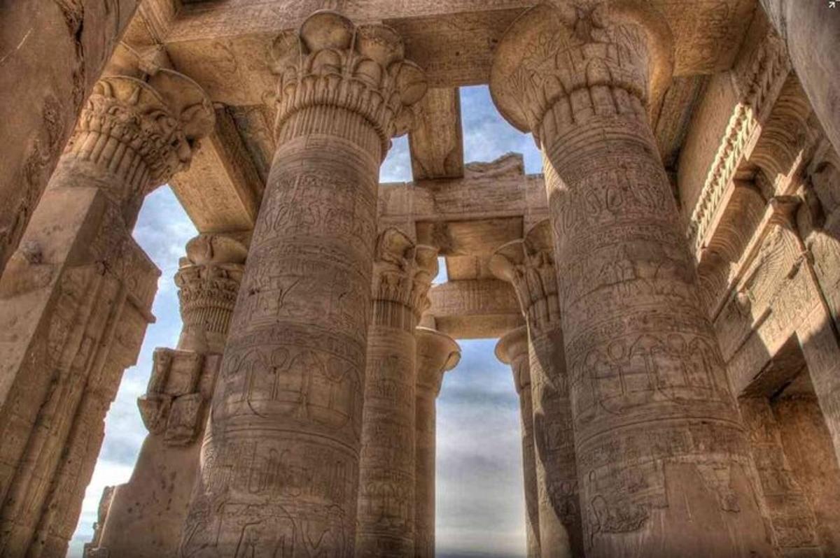 Un edificio antiguo con columnas con un fondo de cielo.