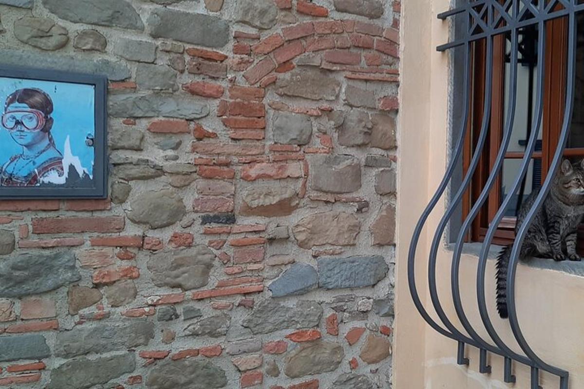 o pisică stând pe pervazul unei ferestre lângă un zid de cărămidă