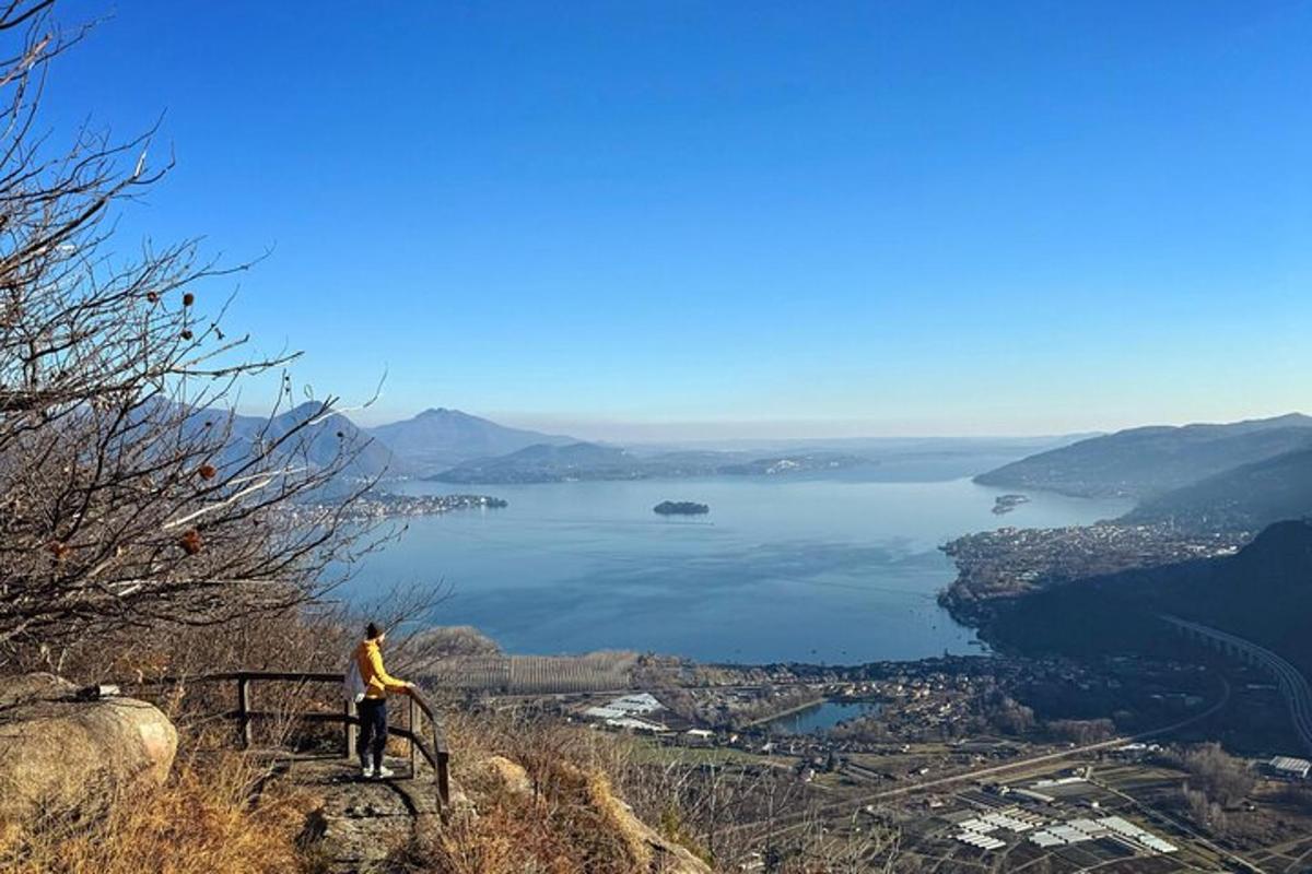 seorang lelaki berdiri di atas bukit yang menghadap ke tasik