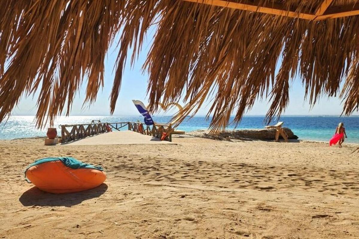 una spiaggia con un ombrellone di paglia e l'oceano