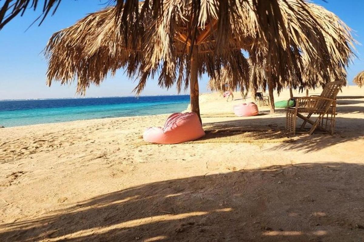una spiaggia con un ombrellone e delle sedie e l'oceano