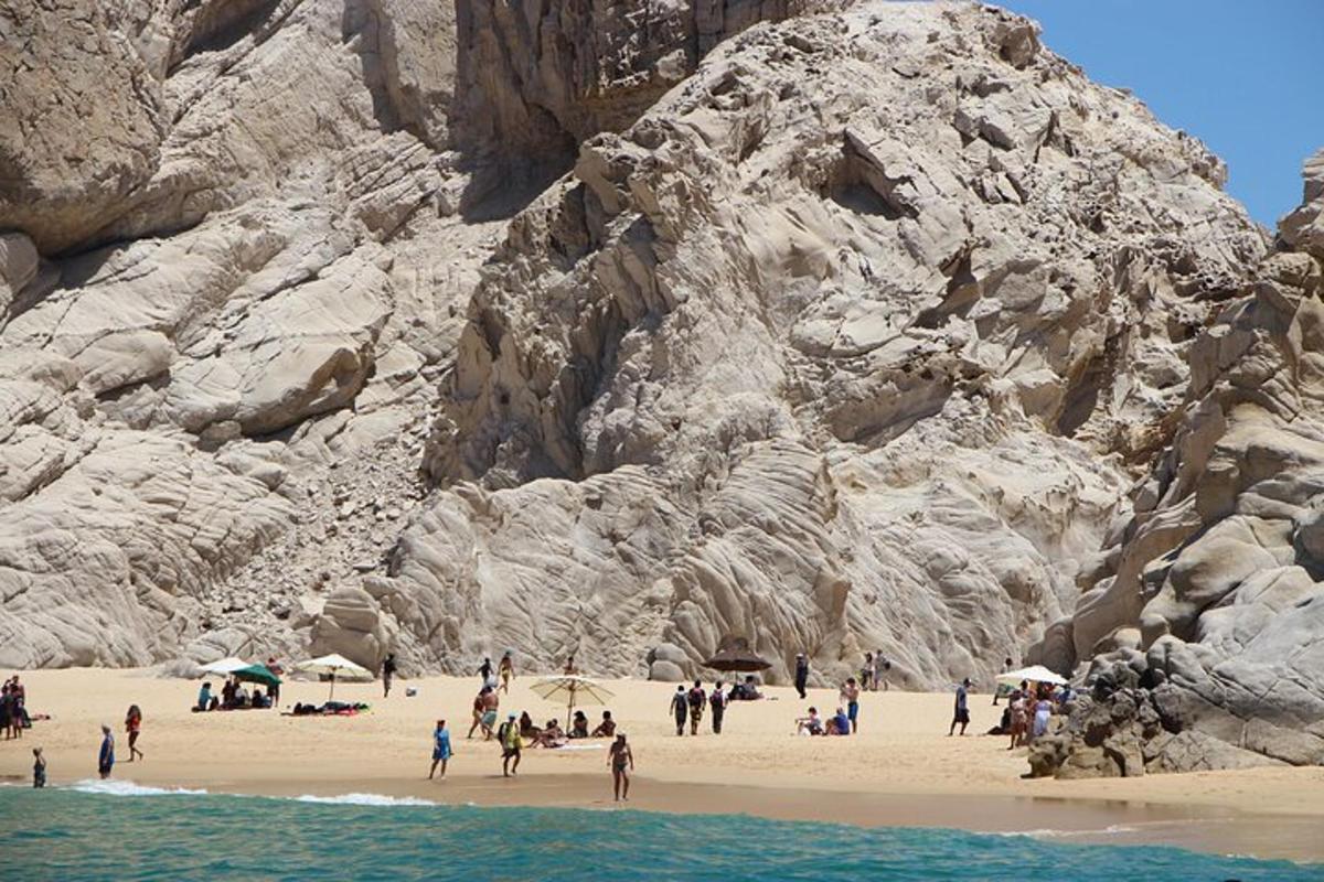 a group of people on a beach near a mountain