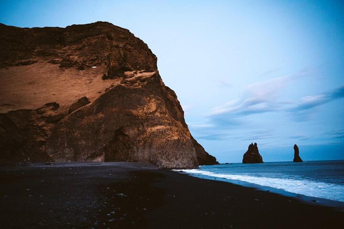 a black beach with rocks in the ocean