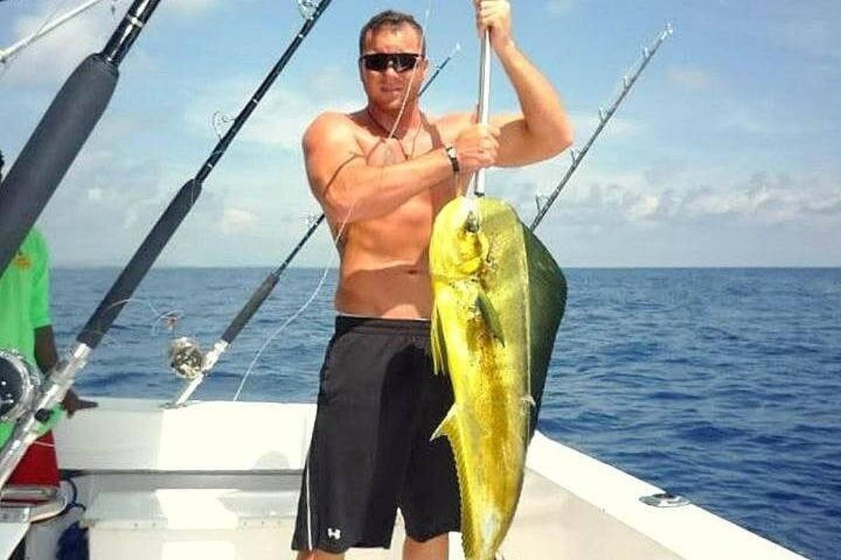 a man holding a fish on a boat