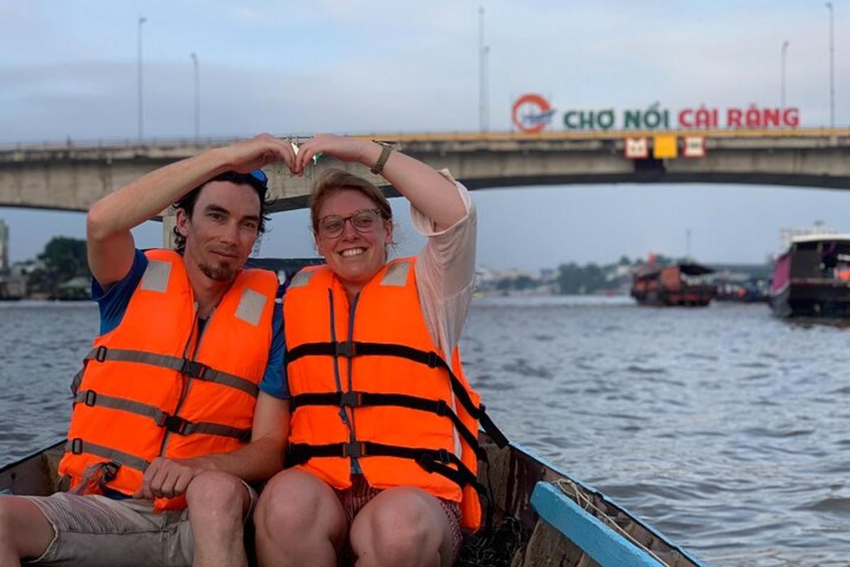 Dos hombres con chalecos salvavidas naranjas en un bote en el agua