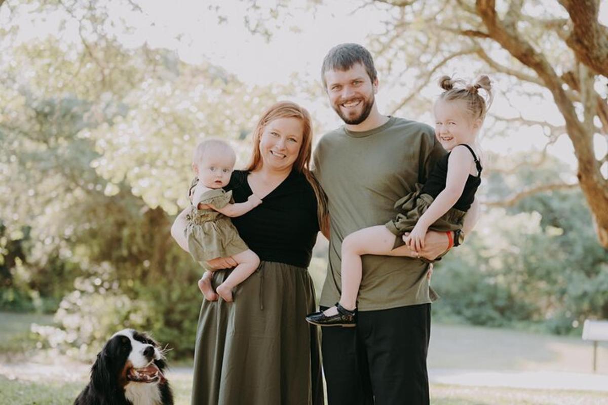 a man and his wife and two children and a dog
