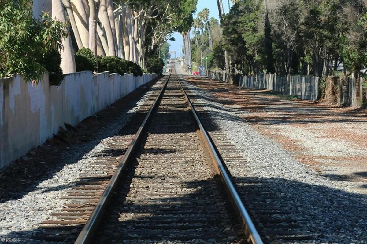 Una vía de tren vacía junto a una valla
