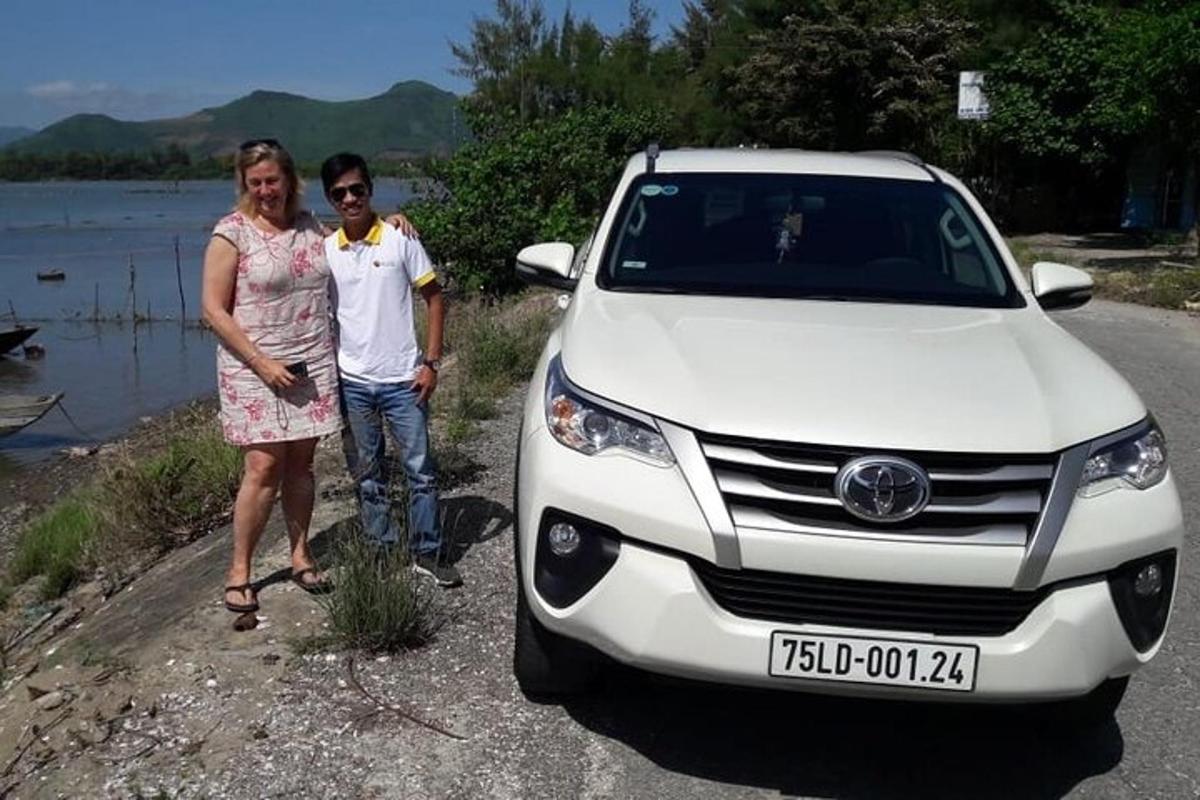 un uomo e una donna in piedi accanto a un'auto bianca