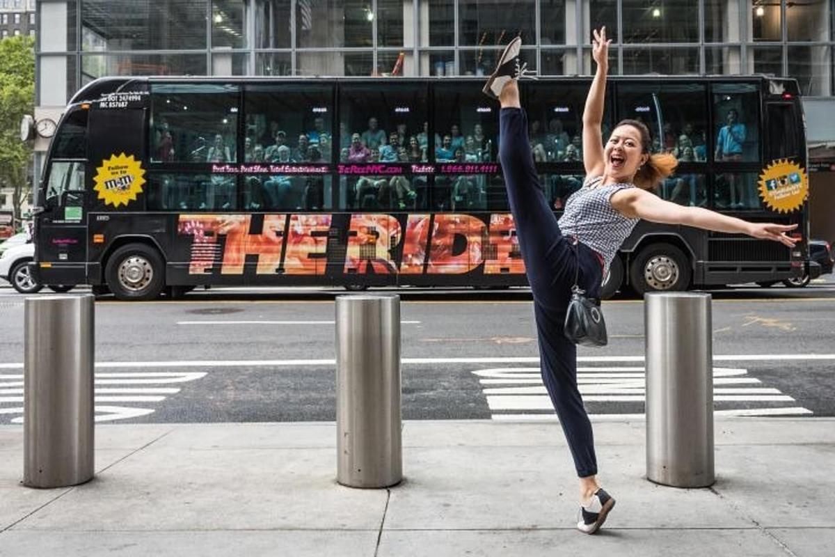 a woman doing a handstand on a pole on a street