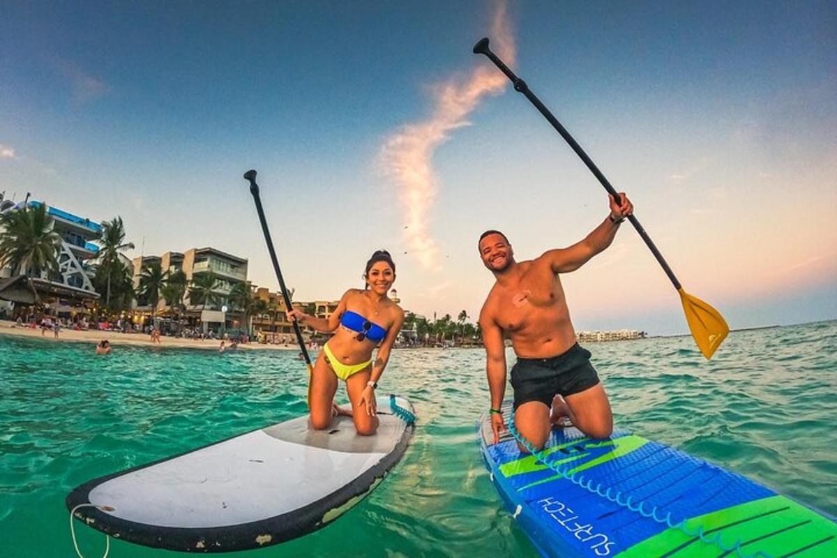 a man and a woman on paddle boards in the water