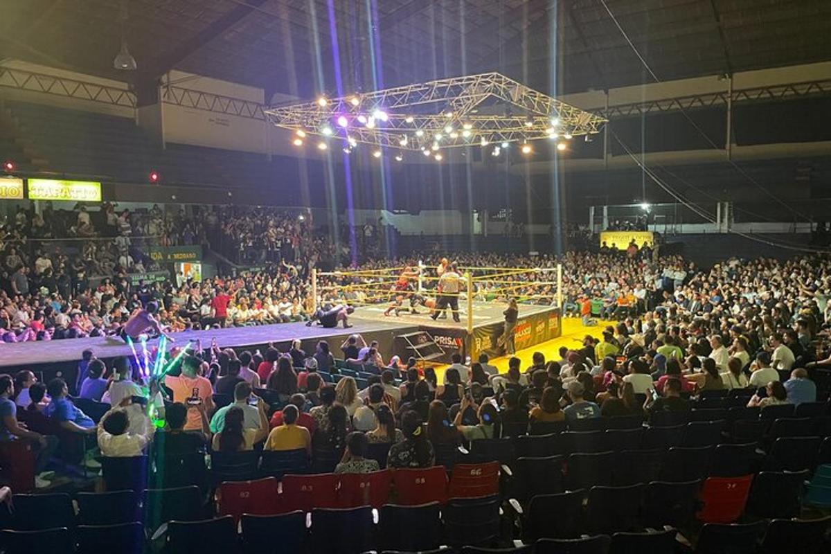 una multitud de persones en una arena amb un ring de boxa