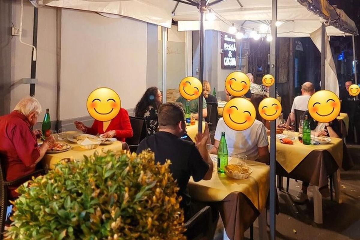 un gruppo di persone sedute a tavoli con volti sorridenti