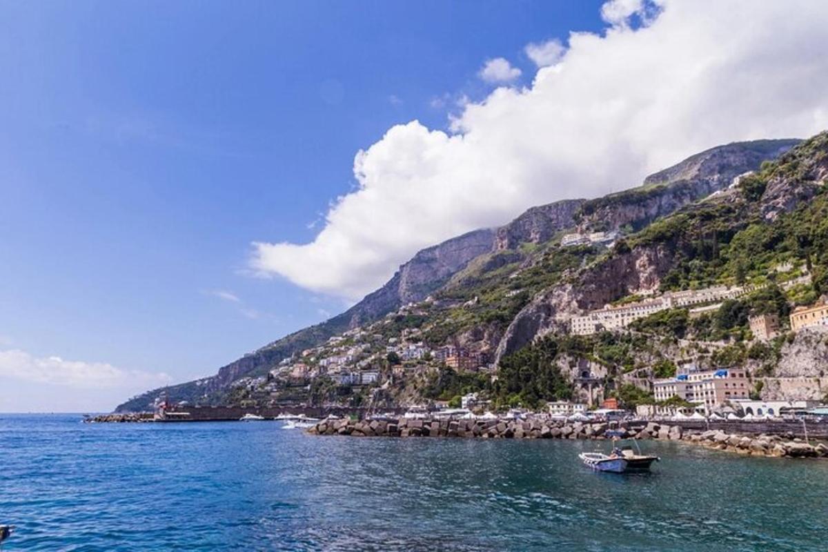 una barca in acqua accanto a una montagna
