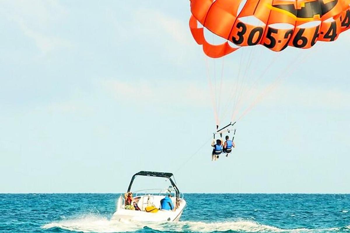 skupina lidí letících na padáku nad oceánem