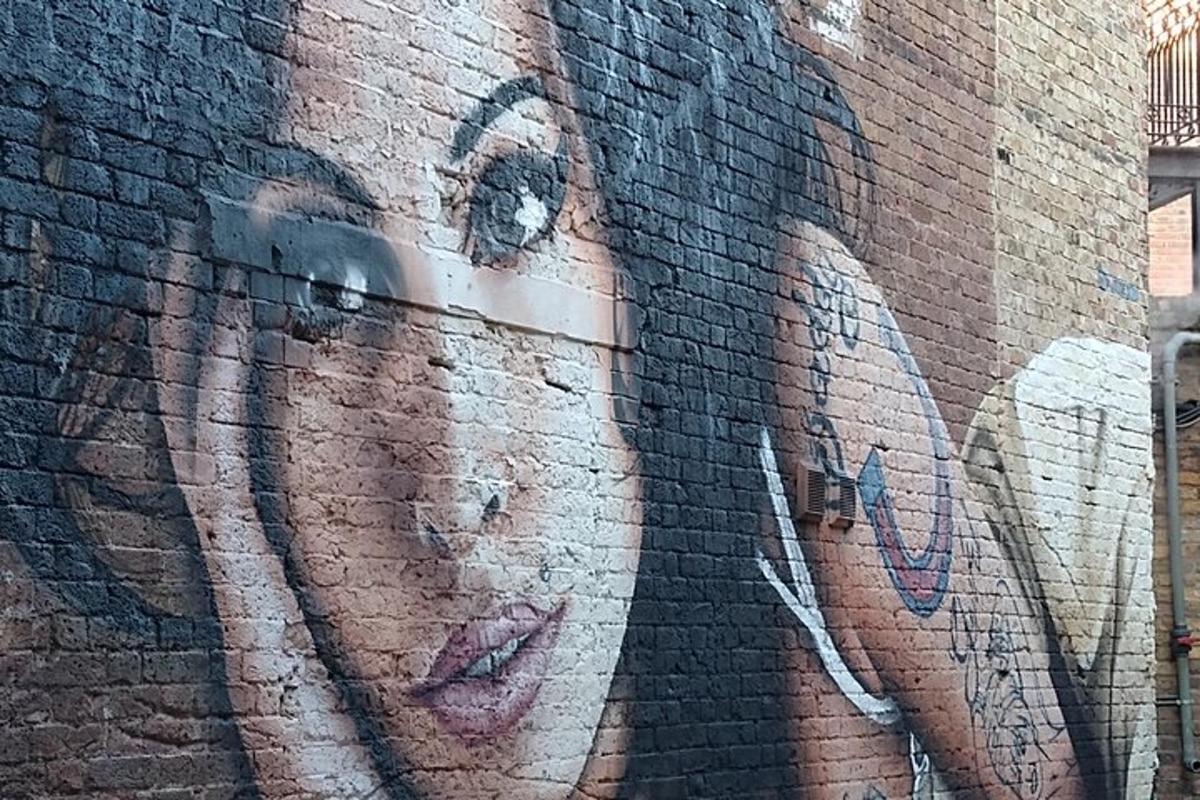 Una mujer pintada en el costado de una pared de ladrillos