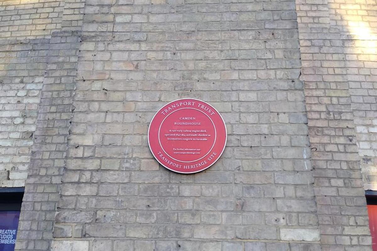 una placa roja en el costado de una pared de ladrillos