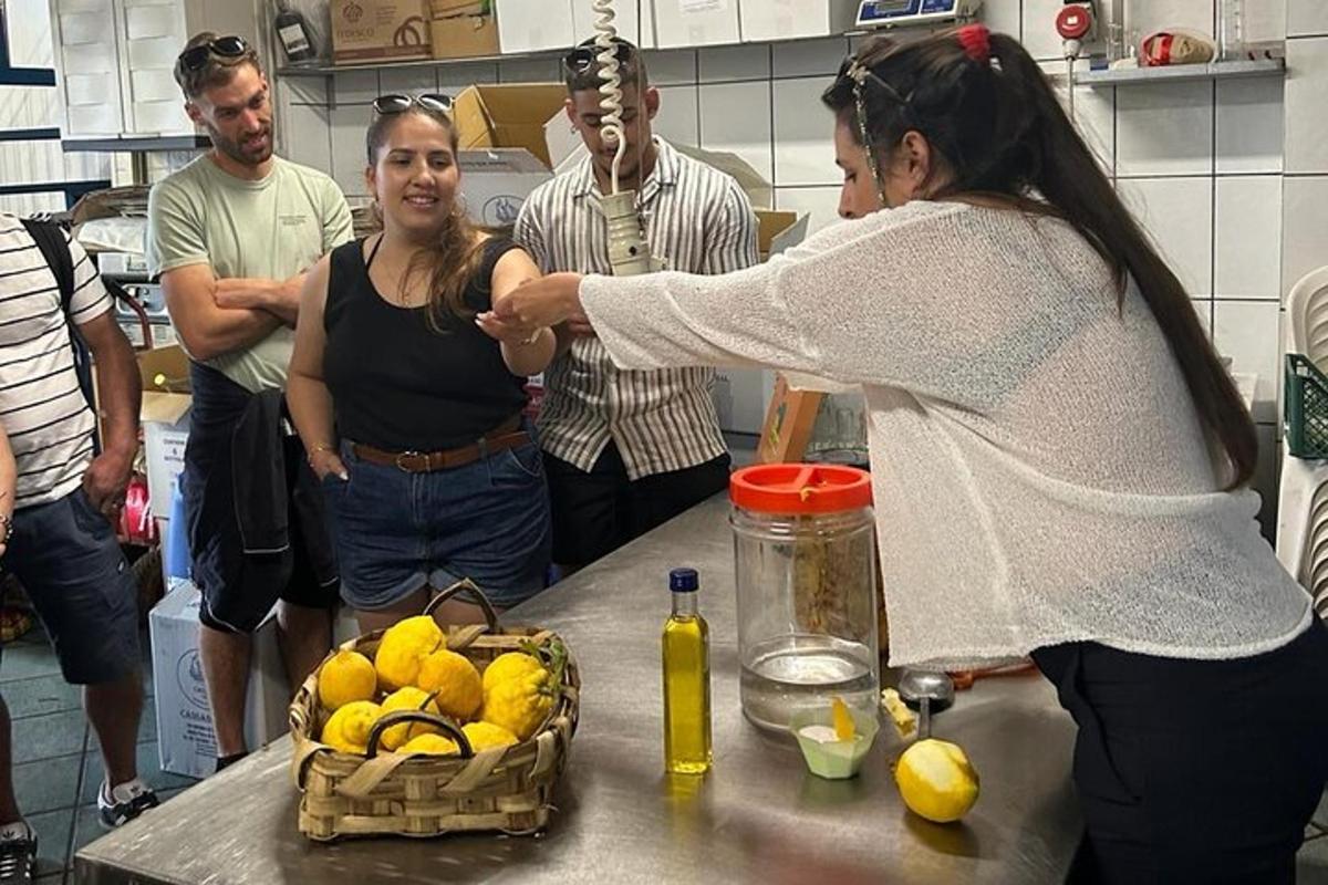 Μια γυναίκα που στέκεται σε μια κουζίνα με μια ομάδα ανθρώπων