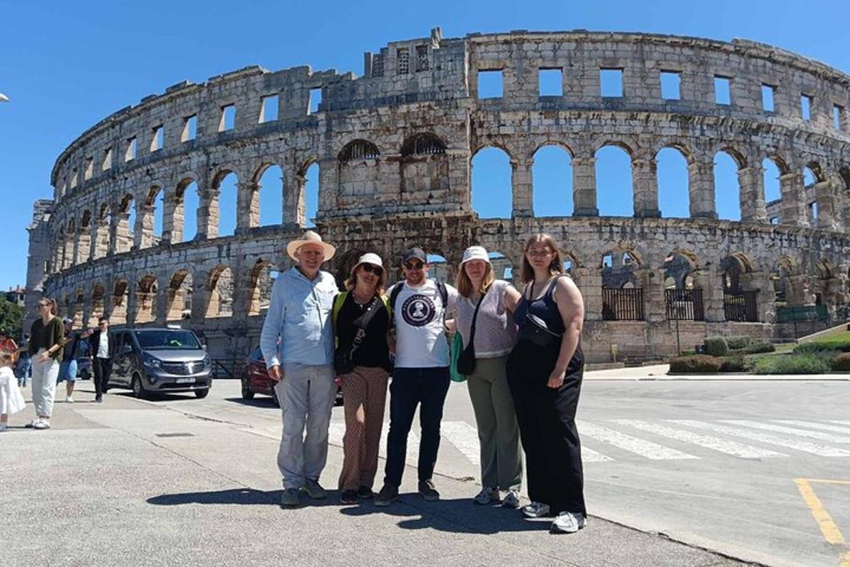 a group of people standing in front of the coliseum