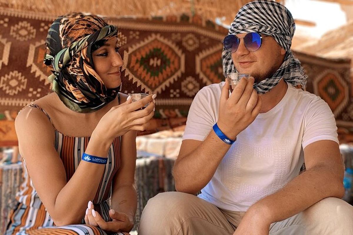 a man and woman sitting next to each other looking at their cell phones