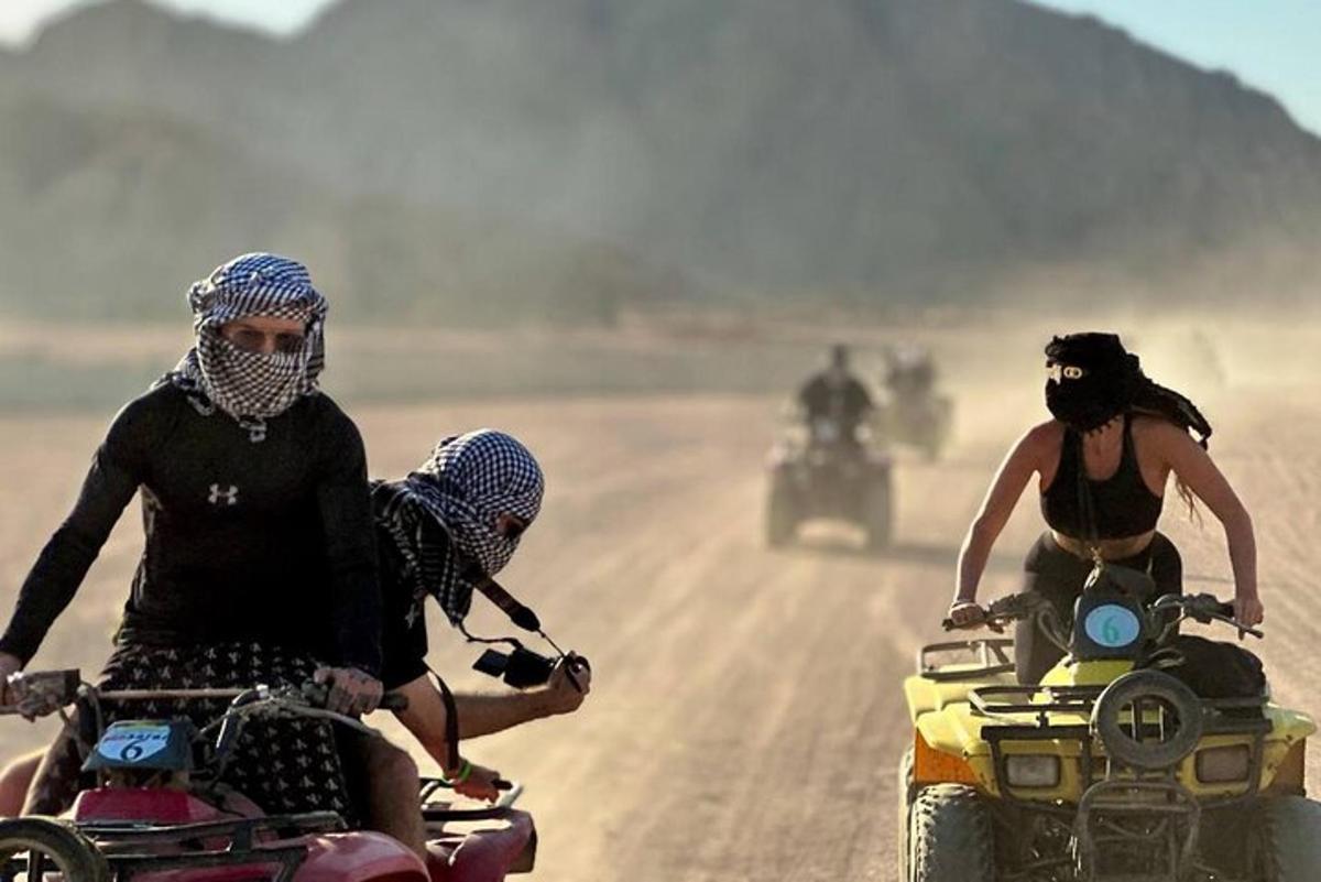 skupina ljudi, ki vozijo motorje po makadamski cesti