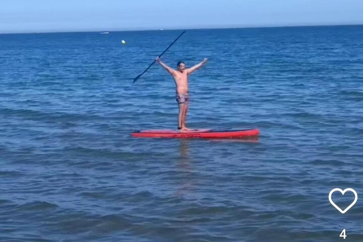muž stojící na paddleboardu v oceánu