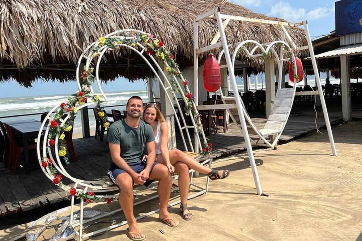 Un hombre y una mujer sentados en un columpio en la playa