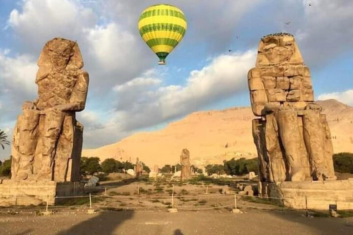 isang hot air balloon ang lumilipad sa ibabaw ng mga estatwa ng dalawang ulo