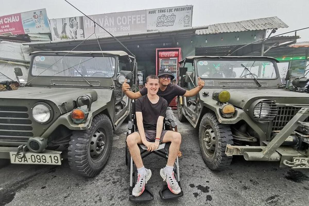 moški, ki sedi na invalidskem vozičku poleg dveh vojaških tovornjakov