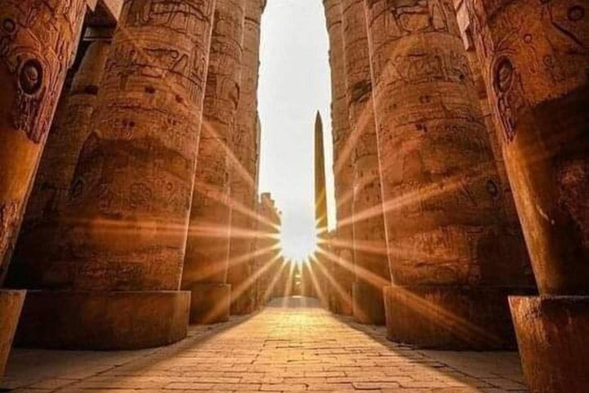 un arco di un edificio con il sole sullo sfondo
