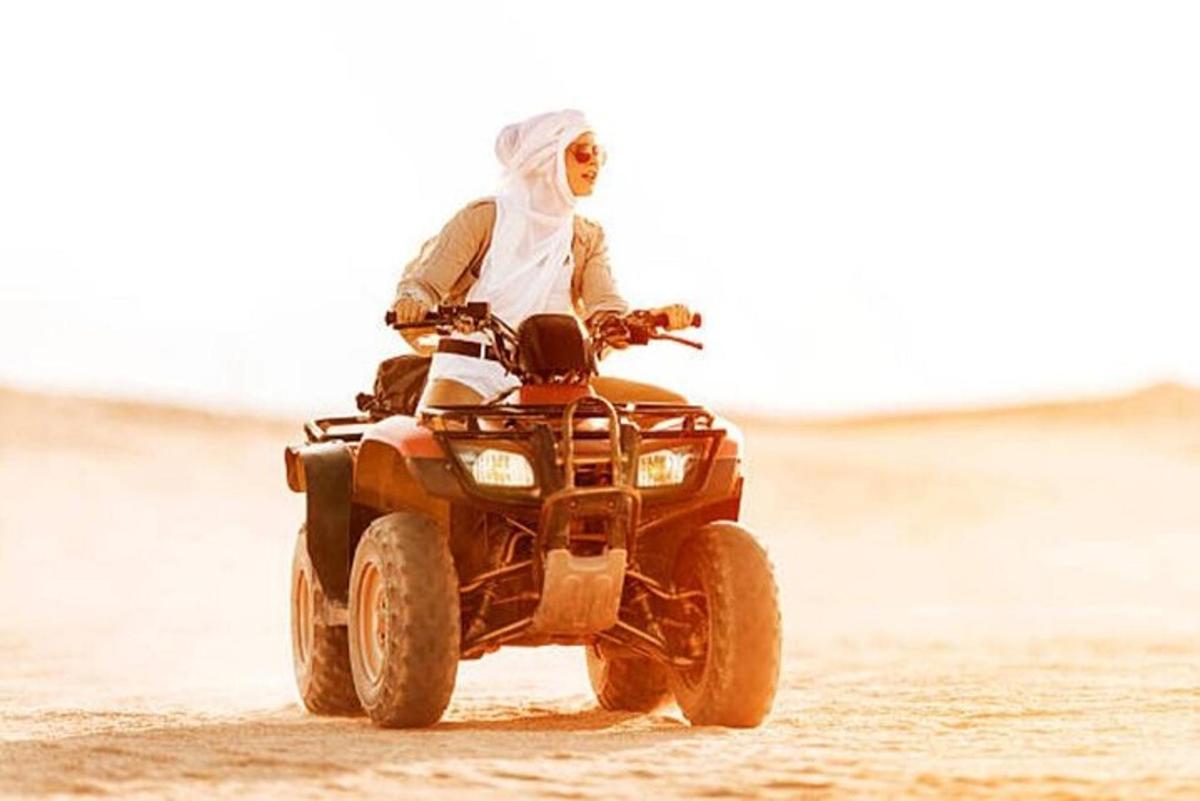 una persona che guida un quad sulla spiaggia