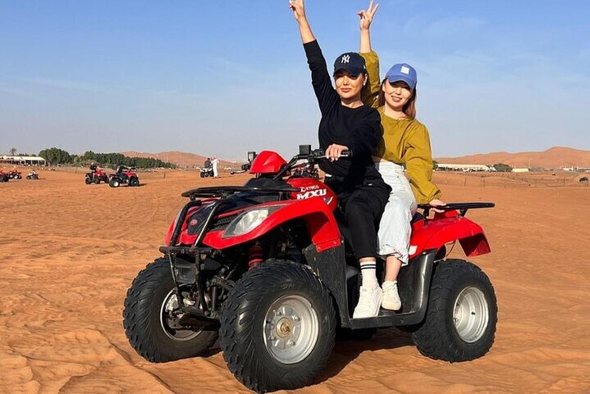 due persone a bordo di un veicolo a quattro ruote nel deserto