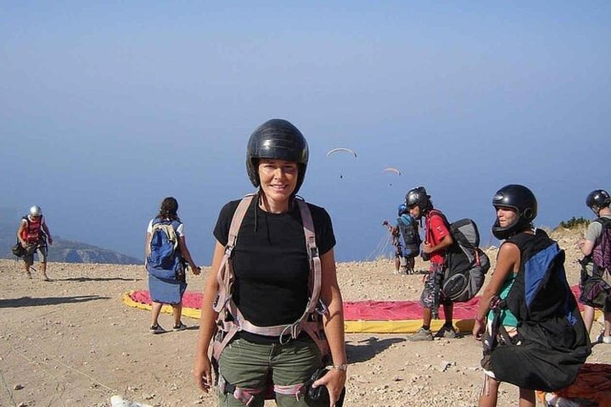 a group of people wearing helmets standing on a beach