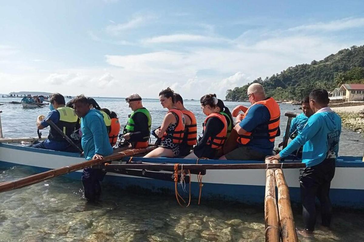 un gruppo di persone sedute su una barca in acqua