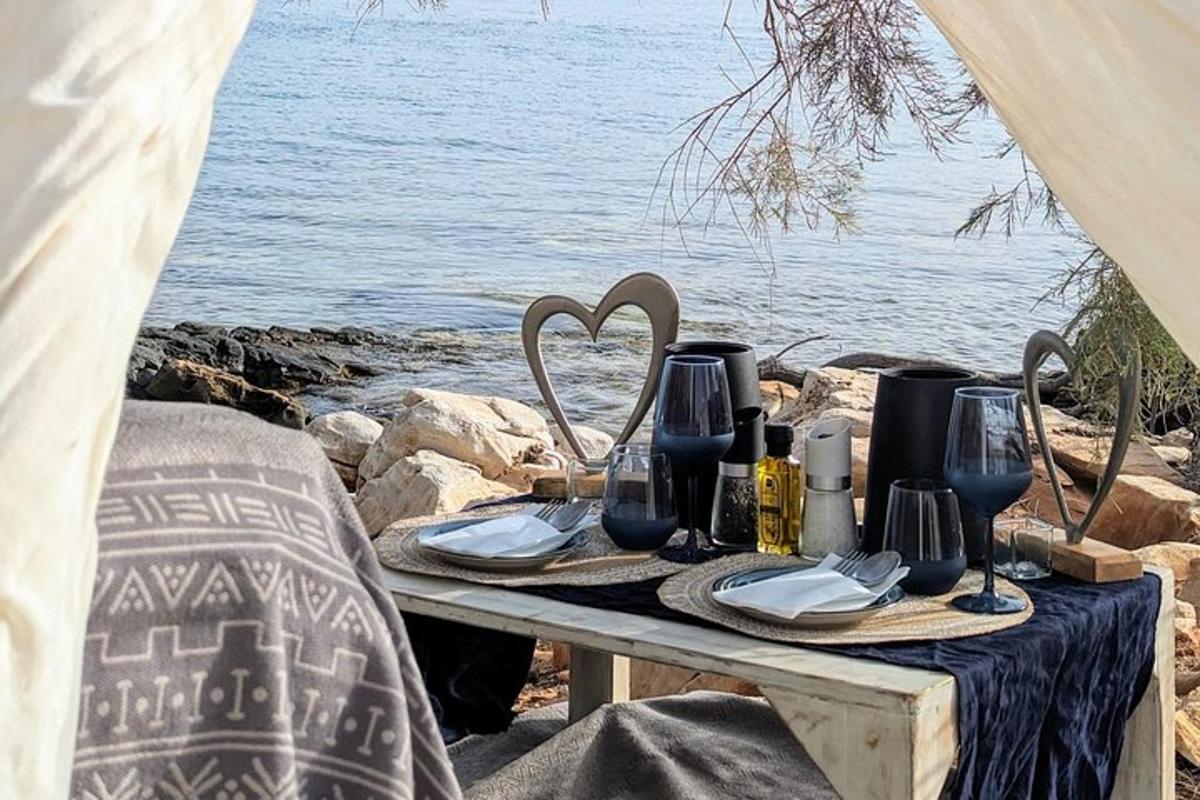 o masă de picnic cu o masă pusă cu pahare de vin
