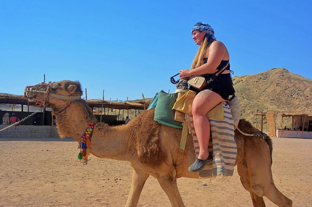 a woman riding on the back of a camel