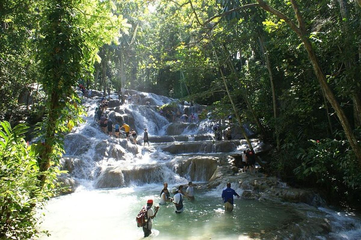 một nhóm người ở dưới nước gần thác nước