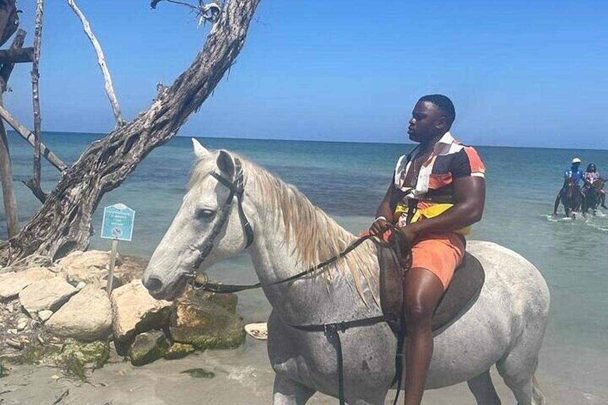 un hombre sentado a caballo en la playa