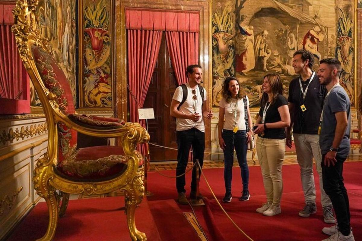 Un grupo de personas de pie junto a una silla en una habitación.