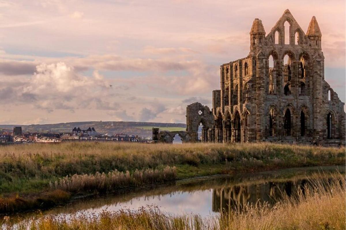 an old church in a field next to a river
