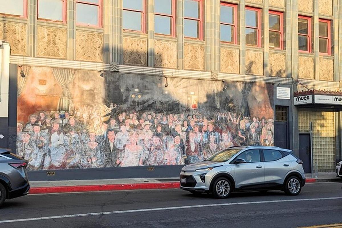 Un coche aparcado delante de un mural en un edificio.