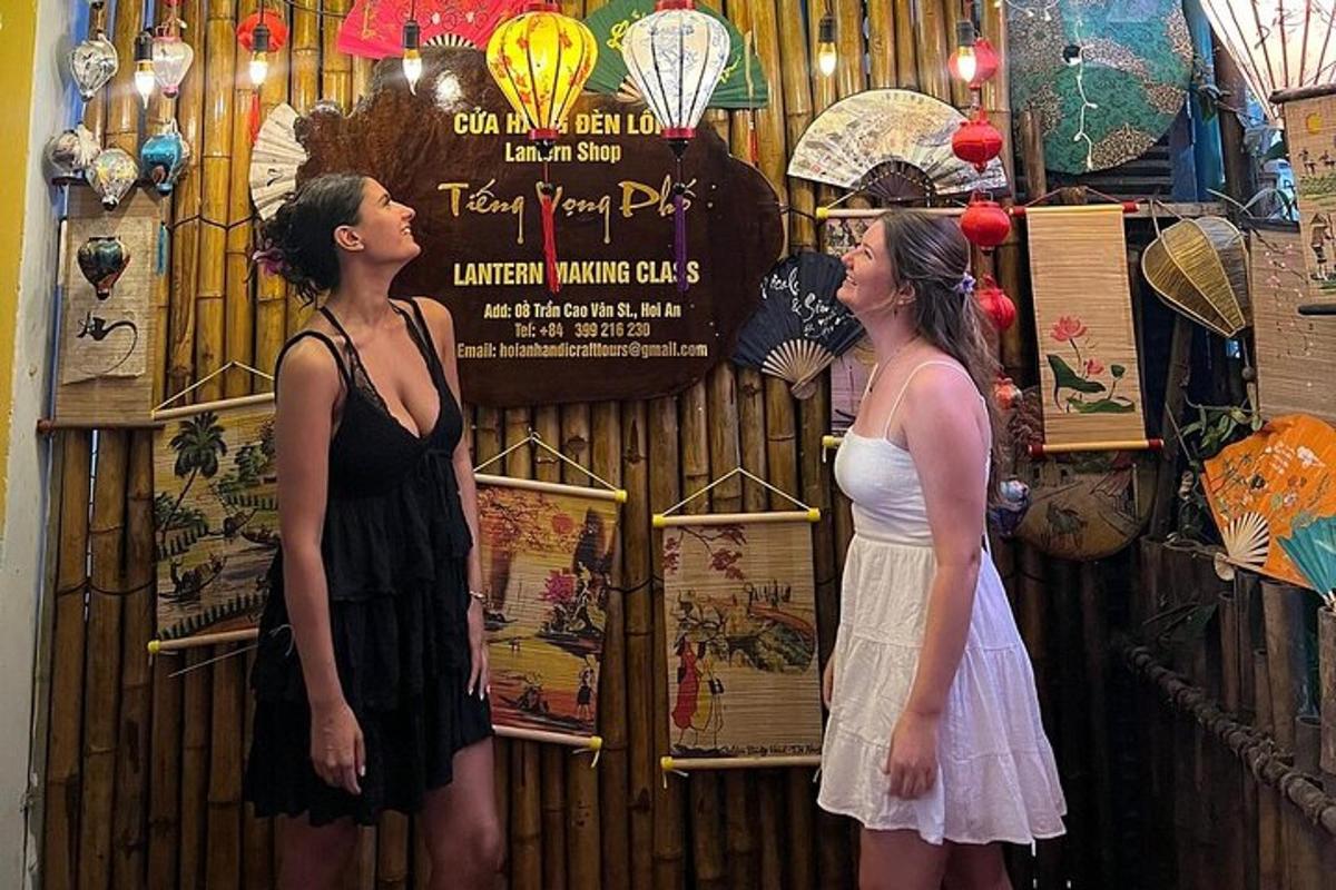 Dos mujeres paradas frente a una pared con carteles.