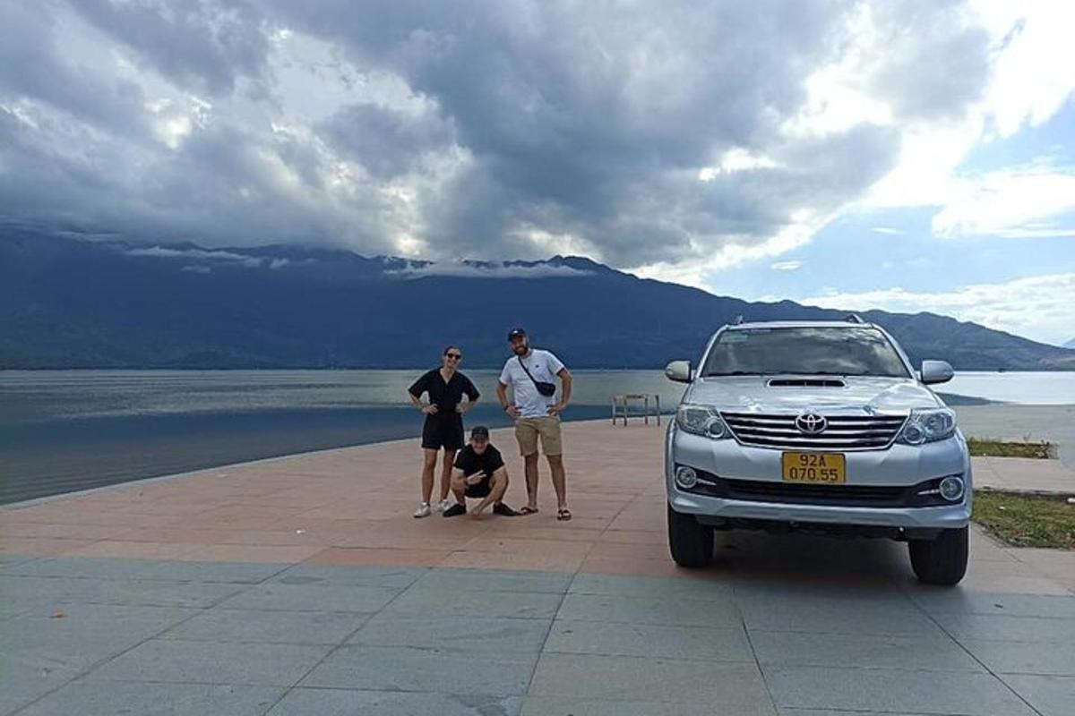 Un grupo de personas de pie junto a un coche.