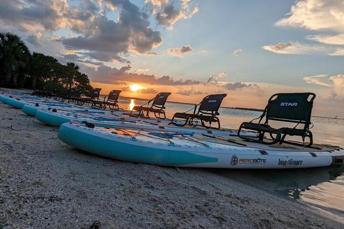 deretan kayak dan kursi di pantai saat matahari terbenam