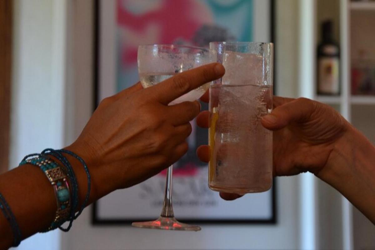 two people holding up a glass of drink